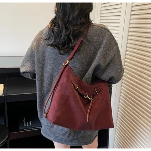 Wine red vintage multi-use shoulder backpack detail view showing soft leather and hardware.