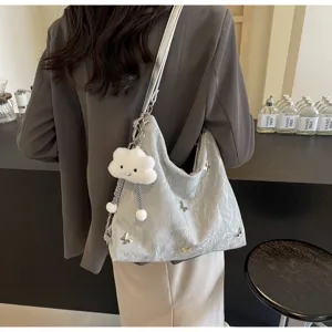 Chic gray crinkled hobo tote bag with butterfly charms and cute fluffy cloud keychain accessory.