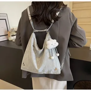 Detailed view of grey crinkled tote backpack with cute cloud pendant and butterfly charms.