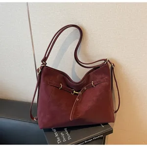 Burgundy retro convertible shoulder bag detail, multi-way strap and metal buckle accent.