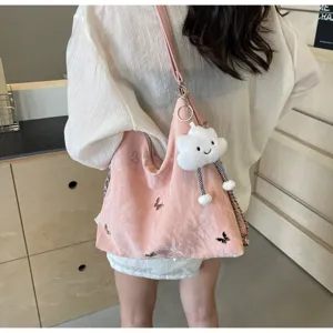 Pink tote bag detail showing metal butterflies and cute cloud keychain for casual daily commuting.