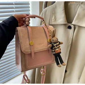 Vue de détail d'un sac à dos rose tendance avec pendentif lapin et mélange de cuir chic.
