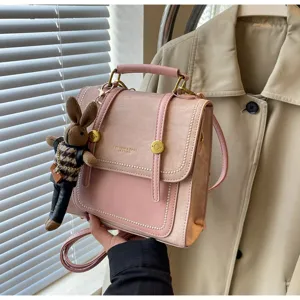 Détail de sac à dos en cuir PU rose, sac à main tendance avec joli pendentif lapin en peluche.