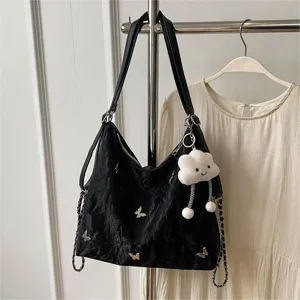 Black canvas tote shoulder bag with butterfly decorations and cute cloud keychain pendant.