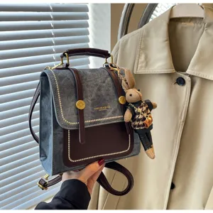 Petit sac à dos chic en jean et cuir avec charmant pendentif de lapin en tricot.