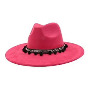 Close-up detail view of the vibrant magenta felt jazz hat featuring ethnic pom-pom band trim.