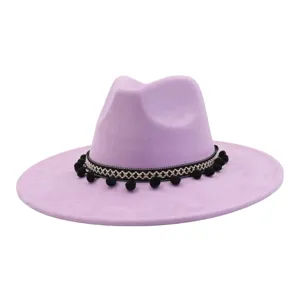 Close-up of lavender wide-brim fedora hat featuring black-white woven band and pom-poms.