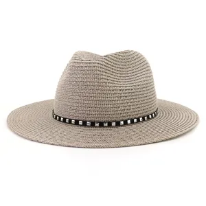 Vue détaillée du chapeau fedora en paille grise avec bande noire chic et rivets métalliques.