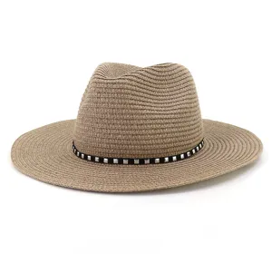 Gros plan sur le chapeau de paille kaki dote d'une bande noire avec des clous en argent.