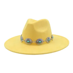 Close-up detail of yellow suede fedora hat with vintage silver concho turquoise band.