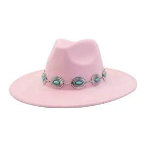 Close-up of pink felt fedora hat featuring western metal turquoise concho decorative band.