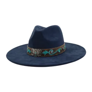 Vista detallada del sombrero azul marino de ala ancha con banda de cuero bordada marrón y hebilla.