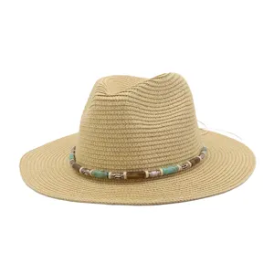 Gros plan sur le chapeau de soleil en paille élégant avec bande de perles et tissage fin.
