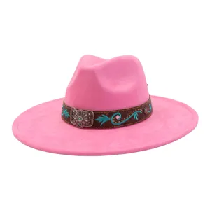 Detalle de sombrero western de ante rosa, bordado turquesa, hebilla metálica y banda.