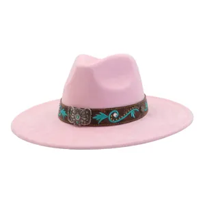 Detalle de sombrero fedora rosa con banda étnica bordada en turquesa y hebilla plateada.