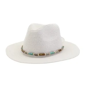 Vue détaillée du chapeau de paille blanc avec bande de perles, idéal pour le soleil de la plage.