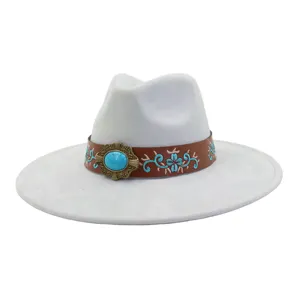 Vista detallada de un sombrero estilo western de ante con hebilla turquesa y bordado.