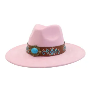 Primer plano detallado del sombrero de lana rosa con correa bordada marrón y hebilla turquesa.