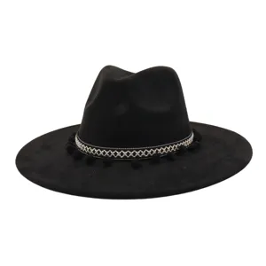 Close-up detail of the black fedora hat showing ethnic woven band and cute pom-poms.