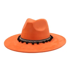 Orange suede jazz hat with ethnic pom pom band and wide flat brim detail close up