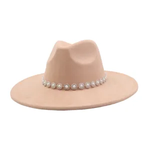 Detailed close-up of a stylish beige suede fedora hat featuring a sparkling pearl rhinestone flower band.