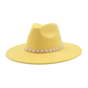 Yellow fedora hat detail featuring sparkling rhinestone pearl flower band decoration close up view.