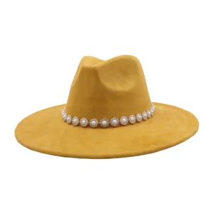 Close-up detail of the mustard yellow suede fedora hat featuring a sparkling pearl rhinestone chain band.
