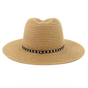 Gros plan d'un chapeau de paille avec détail de bande cloutée noire pour la protection solaire à la plage.