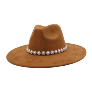 Close-up of brown suede fedora hat featuring elegant pearl and rhinestone flower band detail.