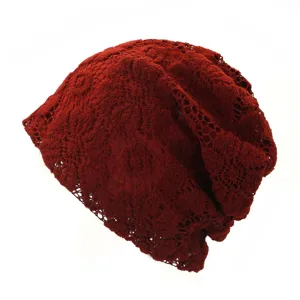 Detail view of a dark red lace slouchy beanie hat, elegant floral hollow out design for women.
