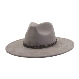 Detail view of grey suede fedora hat featuring a sparkling rhinestone decorative band.