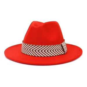 Detail van rode wollen vilt fedora hoed met stijlvolle bruin en wit geweven band.
