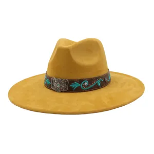 Primer plano del sombrero fedora western de ante amarillo con banda de cuero marrón bordada.