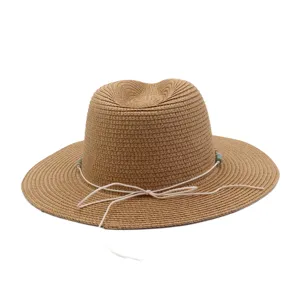 Vue détaillée du chapeau de paille d'été à large bord, cordon blanc et perles pour l'extérieur.
