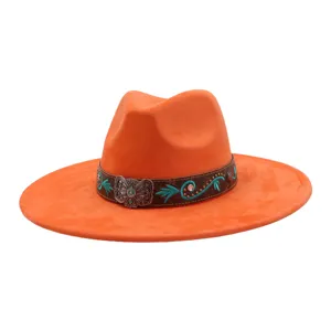 Detalle del sombrero western de ante naranja con bordado turquesa y hebilla de metal.