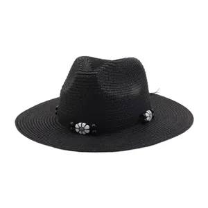 Detailed view of a black straw fedora sun hat featuring black and white beaded flower decor.