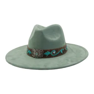 Detalle en primer plano del sombrero fedora de ante con banda marrón y hebilla turquesa.