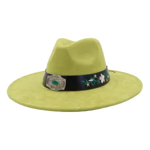 Close-up detail of green suede wide-brim jazz hat with floral embroidery and vintage buckle.