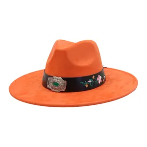 Orange suede fedora hat detail featuring black strap, floral embroidery and green gemstone buckle.