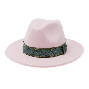 Gedetailleerd uitzicht op de stijlvolle roze fedora hoed met blauw en goud geweven band.