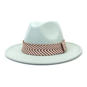 Detail van de mintgroene wol fedora hoed met stijlvolle bruin-witte gewoven hoedband en rand.