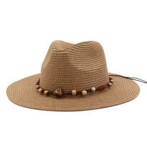 Close-up of a stylish straw fedora sun hat featuring a beaded braided band and wide brim.