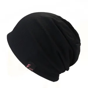Detailed view of the black slouchy knitted beanie hat showing fine rib knit texture.