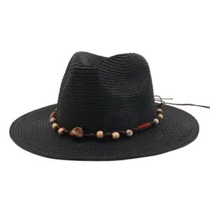 Detailed close-up of the black straw sun hat featuring a decorative beaded cord band style.