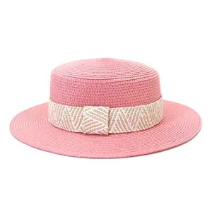 Pink flat top straw hat with patterned ribbon, ideal for summer outdoor travel and sun protection.