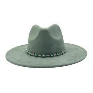 Detailed view of the green suede fedora hat featuring a vintage turquoise chain band.