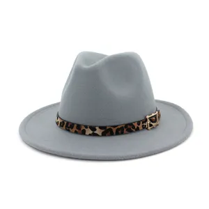 Primer plano detallado del sombrero fedora gris con un elegante cinturón de leopardo y hebilla.