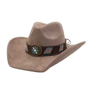 Detailed view of brown suede western cowboy hat with ethnic beaded band and vintage floral metal badge.