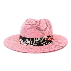 Stilvoller rosa Stroh-Fedora-Sonnenhut mit Blumenband für den Strandurlaub im Sommer.