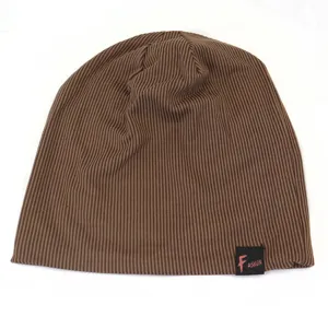 Close-up of brown ribbed knit beanie detail, showing soft texture and edge label.